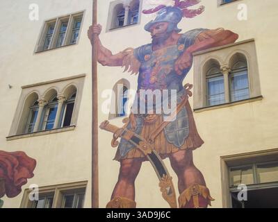 Un grande murale raffigurante un soldato romano in armatura, in piedi con una lancia. Il soldato ha un'espressione feroce ed è decorato con dettagli intricati Foto Stock