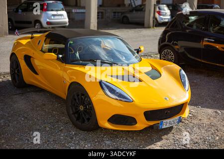 Torino, Italia - 08 novembre 2021: Un'auto sportiva Lotus Elise di colore giallo brillante con ruote nere e spoiler parcheggiata all'aperto su una superficie di ghiaia Foto Stock