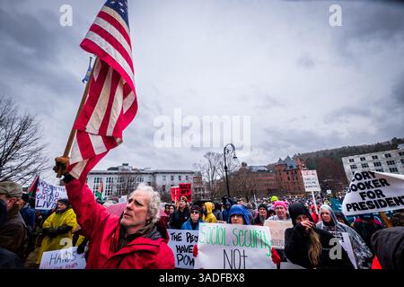 Montpelier, Vermont, Stati Uniti, 5 aprile 2025. Man alza la bandiera americana in occasione di una protesta Trump del 50501 il 5 aprile 2025, presso la Vermont State House di Montpelier, VT, USA, parte dei raduni Hands Off svoltisi in giro per gli Stati Uniti. John Lazenby/Alamy Live News Foto Stock