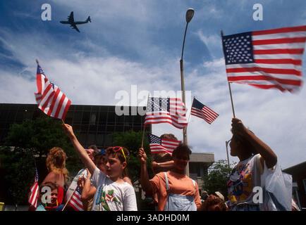 15 giugno 1991; Newburgh, New York, Stati Uniti; gli spettatori guardano come un C5 Galaxy dell'Air Force vola sopra la testa alla parata di apprezzamento militare sventolando le stelle e le strisce della bandiera americana a Newburgh, New York. La parata ha avuto luogo dopo che le truppe statunitensi sono tornate a casa dopo la "guerra del Golfo” contro l'Iraq. . (Immagine di credito: Jack Kurtz/ZUMAPRESS.com) Foto Stock