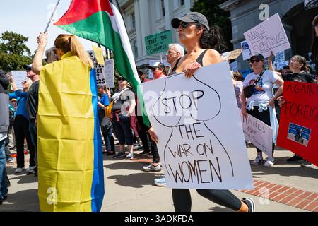 Sacramento, CA U.S.A. - 5 aprile 2025: Una donna tiene un cartello su come fermare la guerra alle donne alla protesta del 50501 sul Campidoglio. Foto Stock