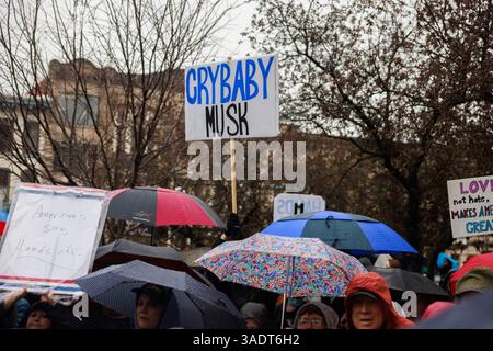 Bloomington, Stati Uniti. 5 aprile 2025. BLOOMINGTON, INDIANA - 5 APRILE: Una persona ha un cartello con la scritta "Crybaby Musk", mentre centinaia di manifestanti partecipano a una manifestazione "mani fuori" per manifestare contro il presidente degli Stati Uniti Donald Trump al tribunale della contea di Monroe il 5 aprile 2025 a Bloomington, Indiana. Le proteste contro le politiche amministrative di Trump e il Dipartimento di efficienza del governo (DOGE) di Elon Musk si svolgono a livello nazionale in quella che gli organizzatori chiamano giornata nazionale d'azione. ( Crediti: Jeremy Hogan/Alamy Live News Foto Stock