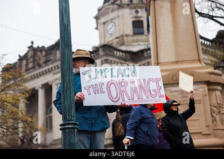 Bloomington, Stati Uniti. 5 aprile 2025. BLOOMINGTON, INDIANA - 5 APRILE: Un manifestante ha un cartello con la scritta "Impeach the Orange", mentre centinaia di manifestanti partecipano a una manifestazione "Hands Off" per manifestare contro il presidente degli Stati Uniti Donald Trump al tribunale della contea di Monroe il 5 aprile 2025 a Bloomington, Indiana. Le proteste contro le politiche amministrative di Trump e il Dipartimento di efficienza del governo (DOGE) di Elon Musk si svolgono a livello nazionale in quella che gli organizzatori chiamano giornata nazionale d'azione. ( Crediti: Jeremy Hogan/Alamy Live News Foto Stock