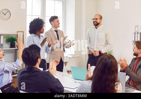 Gruppo diversificato di supporto, il team degli uffici degli uomini d'affari si congratula con il dipendente entusiasta per la promozione Foto Stock