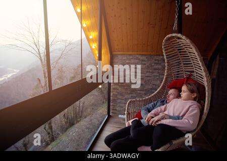 Padre e sua figlia, seduti sull'amaca e guardando le montagne di Variaki, Georgia Foto Stock
