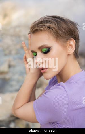 Ritratto di una bella modella femminile con gli occhi chiusi. Volto di una bella donna con trucco e capelli corti. Sensualità donna relax all'aperto aga Foto Stock