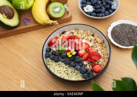 Sana prima colazione con frullato di avocado con frutta fresca e semi di chia su un tavolo di legno Foto Stock