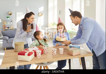 Buon compleanno in famiglia divertente festa a casa, genitori simpatici ridendo, due bambini che ridono Foto Stock