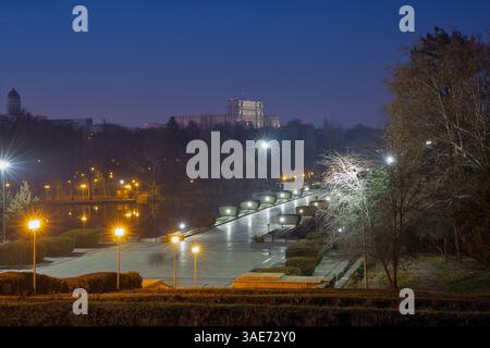 Vista dal National Heroes Memorial sul Carol Park di notte con il lago e il Palazzo del Parlamento sullo sfondo. Bucarest, Romania. Foto Stock