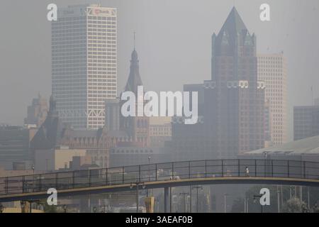 13 settembre 2011 - Milwaukee, WISCONSIN, Stati Uniti - Un pedone attraversa un ponte pedonale con uno skyline nebuloso di Milwaukee sullo sfondo, 13 settembre 2011. Un enorme incendio boschivo nella Boundary Waters Canoe area in Minnesota ha mandato cenere e fumo in gran parte del Wisconsin, compresa la metropolitana di Milwaukee. (Immagine di credito: © Mike De Sisti/Milwaukee Journal Sentinel/MCT/ZUMAPRESS.com) Foto Stock