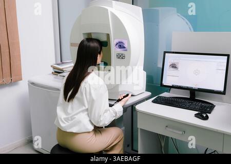 Perimetria occhi test per segno precoce di glaucoma di donna paziente di oftalmologia clinica. Test del campo visivo di perimetria per misurare tutte le aree della vista Foto Stock