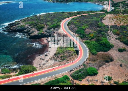 Vista aerea di una strada tortuosa, costa rocciosa e alberi verdi Foto Stock
