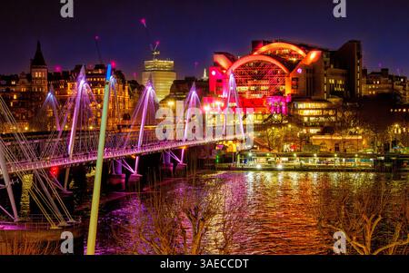 Vista notturna della stazione ferroviaria di Charing Cross e del ponte Hungerford sul Tamigi tra la South Bank e Westminster a Londra, Regno Unito Foto Stock