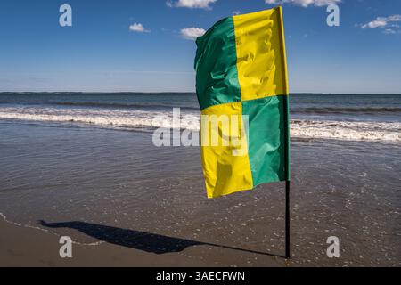 Bandiera bagnino su una spiaggia in una giornata di sole. Foto Stock