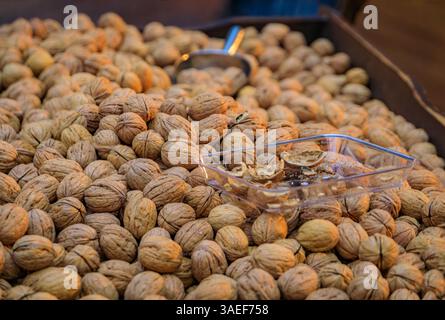 Noci intere fresche in conchiglie esposte in una scatola con paletta in metallo in vendita alla rinfusa in un vivace bazar di Istanbul, Turchia Foto Stock
