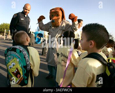 7 ottobre 2009 - SAN DIEGO, CA, USA Ð McGruff, il cane che combatte il crimine, Center, si flette i muscoli mentre lui e il suo partner, l'ufficiale di polizia di San Diego, Edwin Garrette, lasciavano, salutavano gli studenti della Central Elementary School di City Heights durante un'assemblea scolastica per la giornata internazionale della camminata verso le scuole. L'assemblea e la passeggiata per la scuola da Teralta Park si sono svolte per aumentare la consapevolezza della sicurezza dei pedoni ed è stata in parte sponsorizzata da Rady ChildrenÕs Hospital e Safe Kids San Diego. (Immagine di credito: San Diego Union-Tribune/ZUMAPRESS.com) Foto Stock