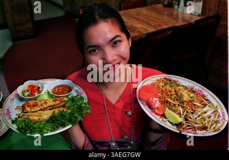 SP 24059 consegna a: Flo 4/16/96 - San Pietroburgo - giugno Tepwong, proprietario e direttore del ristorante 9 Bangkok. Sta posando con L to R-- Satay, un antipasto di pollo, e Pad Thai, un piatto principale di spaghetti di riso. Times foto di: CHERIE DIEZ Story di: Casey Data esecuzione: 25 aprile 1996 scansionato da: cd (Credit Image: Tampa Bay Times/ZUMAPRESS.com) Foto Stock