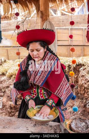 Donna peruviana in abiti tradizionali nel villaggio di Chinchero negozio di artigianato tessile che mostra ai turisti come fare e dipingere tessuti di lana di alpaca Foto Stock