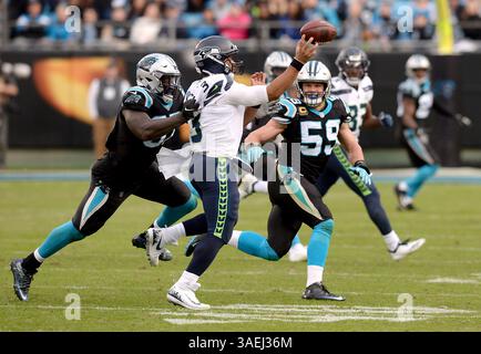 1 gennaio 2012 - Charlotte, NC, USA - il quarterback dei Seattle Seahawks Russell Wilson esce dalla tasca per passare a un ricevitore come il defensive end dei Carolina Panthers Mario Addison, a sinistra, e il linebacker Luke Kuechly, a destra, fanno pressione domenica 25 novembre 2018 al Bank of America Stadium di Charlotte, N.C. i Seahawks sconfissero i Panthers 30-27. (Immagine di credito: © Jeff Siner/Charlotte Observer/TNS via ZUMA Wire) Foto Stock