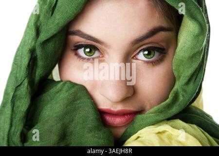 Ritratto di misteriosa bella ispanica caucasica Latina donna faccia verde con occhi penetranti e moda verde sciarpa avvolta attorno alla testa, isolare Foto Stock