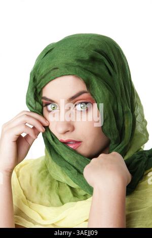 Ritratto di timido misteriosa bella ispanica caucasica Latina donna faccia verde con occhi penetranti e moda verde sciarpa avvolta attorno alla testa, iso Foto Stock