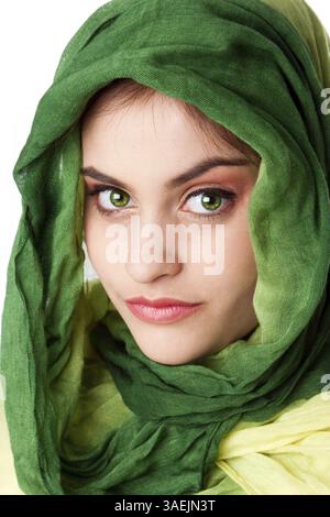 Ritratto di misteriosa bella ispanica caucasica Latina donna faccia verde con occhi penetranti e moda verde sciarpa avvolta attorno alla testa, isolare Foto Stock