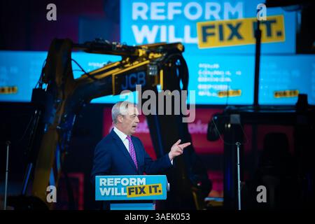 Nigel Farage, leader della riforma del Regno Unito, arriva tramite JCB per rivolgersi ai membri del partito. Birmingham Regno Unito. Foto Stock