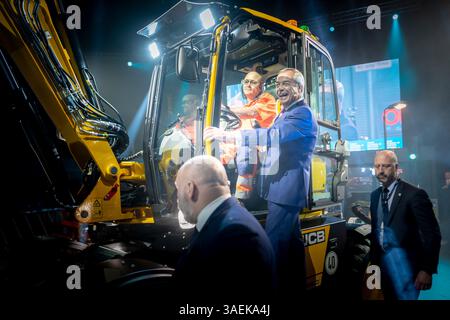 Nigel Farage, leader della riforma del Regno Unito, arriva tramite JCB per rivolgersi ai membri del partito. Birmingham Regno Unito. Foto Stock