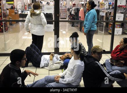 24 novembre 2011 - Albuquerque, NEW MEXICO, Stati Uniti - 112411.gli acquirenti attendono fuori da Kohl's per la loro apertura di mezzanotte al Coronado Center, che ha dato il via allo shopping del Black Friday al negozio, 25 novembre 2011, ad Albuquerque, N.M. aspettando vicino alla porta d'ingresso, Delilah Rios si trova sul pavimento, riposando su sua sorella Daniella Coby. Hanno iniziato ad aspettare l'apertura alle 21 (immagine di credito: © Marla Brose/Albuquerque Journal/ZUMAPRESS.com) Foto Stock