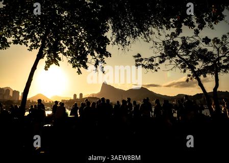 Sagome di persone che guardano il tramonto sul lungomare di Urca con il monte Corcovado - Rio de Janeiro, Brasile Foto Stock