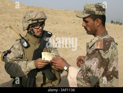 10 aprile 2005; Fallujah, Iraq; un primo tenente iracheno, MULAAZEM AWWAL, si prende una pausa dall'addestramento con un Marine del otherÕs Battaglione, Reggimento Marines per discutere ogni lingua. Il personale delle forze di sicurezza irachene sta lavorando fianco a fianco con il ÒLion TrainingÓ Battaglione, il 6° Reggimento Marines, per condurre un programma di per insegnare al nuovo esercito iracheno recluta i fondamentali di tiro, primo soccorso in combattimento, e costumi e cortesie militari. Credito obbligatorio: Foto di Mike Escobar/DOD/ZUMA Press. (©) Copyright 2005 di US DOD Photo Foto Stock