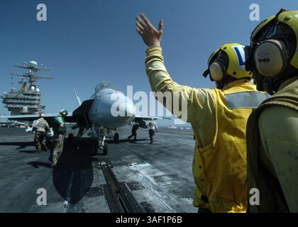8 giugno 2005; Iraq; Aviation Boatswain's Mate 3rd Class Kaylon Boston (destra) tiene d'occhio la spalla di Airman Jonathan Temper mentre esegue l'addestramento per dirigere un F/A-18C Hornet su una delle quattro catapulte alimentate a vapore durante le operazioni di volo a bordo della portaerei USS Carl Vinson. Il Carl Vinson Carrier Strike Group sta conducendo operazioni a sostegno delle forze multinazionali in Iraq e della sicurezza marittima mentre è in corso nel Golfo Persico. Credito obbligatorio: Foto di DOD/ZUMA Press. (©) Copyright 2005 per gentile concessione di DOD Foto Stock