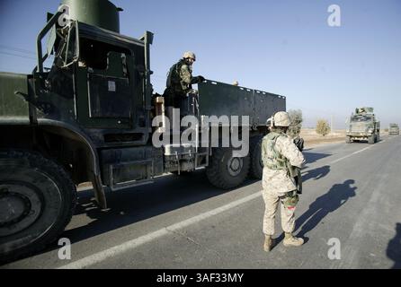 21 dicembre 2004; Fallujah, Iraq; Marine 1st tenente ALEXANDRIA S. PLUCINSKI, comandante di un convoglio con Combat Service Support Company 115, tiene d'occhio la strada mentre fornisce sicurezza al suo convoglio durante una sosta per liberare i detenuti iracheni fuori Fallujah, Iraq, 21 dicembre 2004. L'unità di Camp Pendleton, California, facente parte del 1st Force Service Support Group, è responsabile della fornitura di provviste, come cibo, acqua, munizioni e carburante, alle unità marine che operano a Fallujah e nelle sue vicinanze. A novembre, il CSSC-115 di Camp Pendleton, California, ha registrato più di 31.000 miglia di tempo in strada a supp Foto Stock