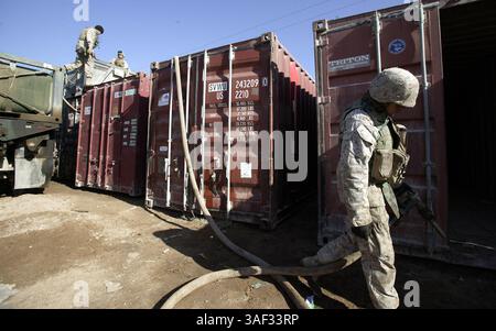 21 dicembre 2004; Fallujah, Iraq; Marine PFC. ARNULFO TORRES, un operatore di veicoli militari con Combat Service Support Company 115, si prepara a pompare carburante da un camion da 7 tonnellate a un contenitore di stoccaggio presso il Logistics Operations Center for 1st Battalion, 3rd Marines, a Fallujah, Iraq, 21 dicembre, 2004. l'unità di Camp Pendleton, California, parte del 1st Force Service Support Group, è responsabile della fornitura di provviste, come cibo, acqua, munizioni e carburante, alle unità marine che operano a Fallujah e nelle sue vicinanze. A novembre, il CSSC-115 di Camp Pendleton, California, ha registrato più di 31.000 miglia di distanza Foto Stock