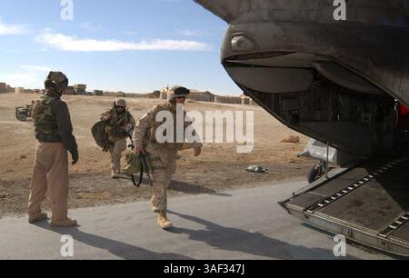 30 dicembre 2004; al Asad, Iraq; Master Sgt. DANIEL S. NICKLE, CH-46E Sea Knight Crew Chief, Marine Medium Helicopter Squadron 365, Marine Aircraft Group 16, 3rd Marine Aircraft Wing, guida un gruppo di passeggeri sul suo elicottero in una base operativa avanzata vicino al confine siriano con l'Iraq dicembre 30. Il trasporto di truppe e merci è una missione ricorrente che lo squadrone esegue per la i Marine Expeditionary Force in Iraq che consente ai Marines di spostare costantemente le loro forze nell'area rapidamente. Foto Stock