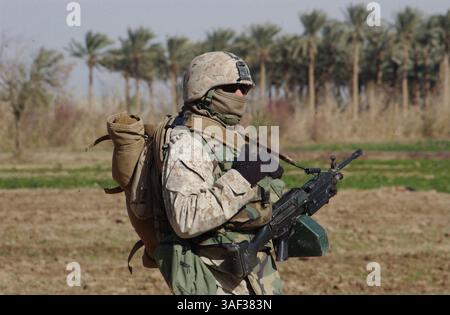 27 dicembre 2004; Ramadi, Iraq; armato con un'arma automatica della squadra e equipaggiamento per il freddo, Lance Cpl. WILLIAM ENGLISH, mitragliere, 1st Platoon, compagnia B, 1st Battalion, il 23rd Marine Regiment, e un ventitreenne nativo di Houston, prende parte ad una pattuglia di sicurezza intorno a Ramadi, Iraq, dicembre 27. Nella tradizione dei loro predecessori in Vietnam, la fanteria marina di oggi in Iraq sta rafforzando un buon rapporto tra governo e civili locali con pattuglie in prima linea di un’insurrezione prima delle elezioni del gennaio 30. Foto Stock