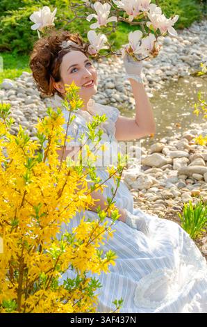 Ritratto di una donna in un abito vintage impero con pizzo su uno sfondo dai colori vivaci Foto Stock