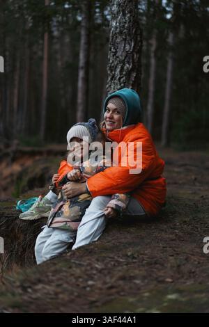 Mamma e figlia in una passeggiata nella foresta invernale Foto Stock
