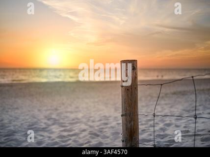 Recinzione Rusty sulla spiaggia con splendido tramonto sull'oceano Foto Stock