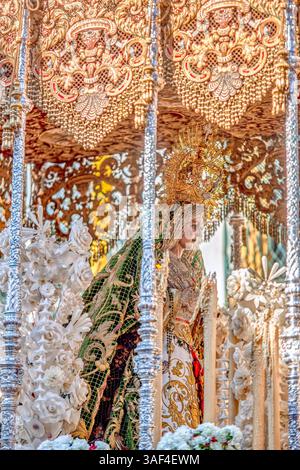 Durante il venerdì Santo di Siviglia, la Vergine di Esperanza Macarena è splendidamente esposta sul suo galleggiante ornato con baldacchino. Foto Stock