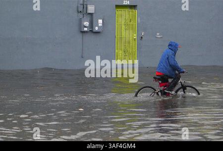 28 febbraio 2015 - Miami, Florida, USA - Un ciclista pedala attraverso una strada allagata mentre molti centimetri di pioggia cadono nel sud della Florida, causando inondazioni diffuse per le strade di Little Haiti, vicino al Little Haiti Cultural Complex di Miami, sabato 28 febbraio 2015. (Immagine di credito: © Carl Juste/TNS/ZUMA Wire) Foto Stock