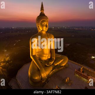 Paesaggio tramonto dietro il grande Buddha d'oro simbolo della Thailandia a wat Muang Ang Thong Thailandia. La statua di Buddha più grande del mondo circondata Foto Stock