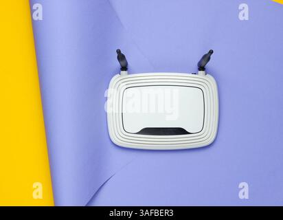 Router Wi-fi su sfondo di carta avvolto. Colori pastello di tendenza, natura morta minimalista. Gadget moderni. Vista dall'alto Foto Stock