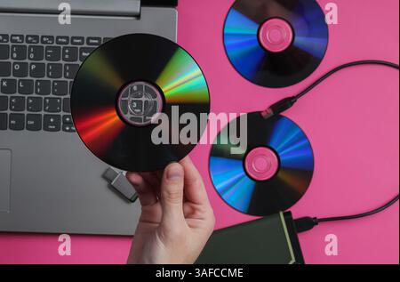 Una donna tiene le unità cd sullo sfondo di gadget. Vista dall'alto Foto Stock