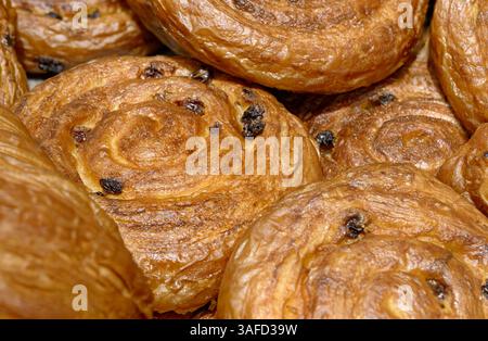 Vari tipi di pasticceria tradizionale a base di pasta sfoglia - croissant e panini con uvetta, primo piano, panetteria astratta Foto Stock