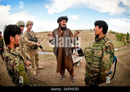 28 aprile 2012 - Ghazni, Afghanistan - il primo tenente TIMOTHY HARTING, leader di plotone della 1st Brigade Combat Team della 82nd Airborne Division, resta in piedi mentre un soldato afghano interroga un abitante del villaggio sulla presenza di talebani nell'area durante una pattuglia combinata nella provincia di Ghazni, Afghanistan. Harting serve con il 2nd Battalion, il 504th Parachute Infantry Regiment. (Immagine di credito: © Michael J. MacLeod/U.S. Esercito/ZUMAPRESS.com) Foto Stock