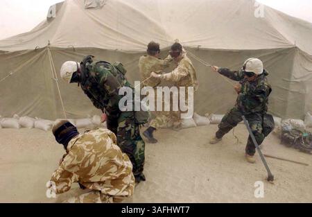NOTA: LE POSIZIONI ESATTE DELLE TRUPPE NON POSSONO ESSERE PUBBLICATE!!!!!! . Soldiers 21 Air Assault Battery della 16th Air Assault Brigade del British Army e US Marines del 1st FSSG davanti al 1 MEF cercano di legare una tenda che ha iniziato a esplodere durante una tempesta di sabbia nel sud dell'Iraq martedì 25 marzo 2003. (Immagine di credito: The Washington Times/ZUMAPRESS.com) Foto Stock