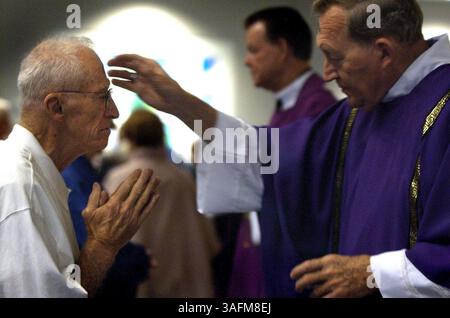 Edward J. McDonough riceve ceneri in segno di croce da Decon Mel Dunphy presso la chiesa cattolica St. Thomas Aquinas a New Port Richey mercoledì 2/25/04. Il nome ufficiale dei giorni è il giorno delle ceneri e cade quaranta giorni prima del venerdì Santo. La croce simboleggia la morte e quindi ci ricorda la nostra mortalità. Le ceneri sono fatte bruciando fronde di palme che sono state salvate dalla domenica delle Palme dell'anno precedente e sono state benedette da un sacerdote. (Immagine di credito: St Petersburg Times/ZUMAPRESS.com) Foto Stock