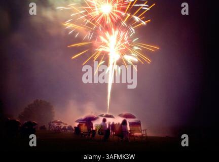 DIDASCALIA: (7/03/04): Gli spettatori si coprono dalle docce a pioggia sotto ombrelloni, teloni e coperte per assistere allo spettacolo di fuochi d'artificio dal Liberty Park di Inverness sabato sera, 3 luglio 2004. La serata Patriottica della città di Inverness, che si è svolta al Wallace Brooks Park e al Liberty Park, comprendeva stand gastronomici, musica e vari giochi per bambini, concludendo con lo spettacolo di fuochi d'artificio al buio. GENERALE: Caratteristica autonoma di Inverness 4 luglio (Credit Image: St Petersburg Times/ZUMAPRESS.com) Foto Stock