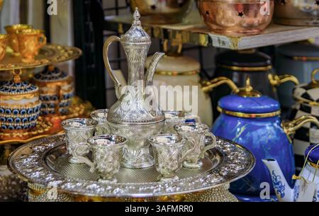 Intricati bicchieri di tè turco al caffè in argento con incisione Zamzam, con una caraffa ornata e tazze su un vassoio presso un bazar di Istanbul, Turchia Foto Stock